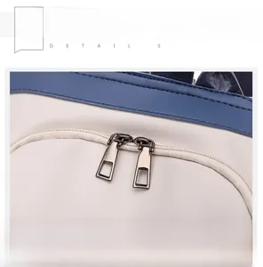 Close-up of two-way metal zipper on white and navy blue soft PU leather backpack