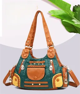 Detail of color-block PU leather handbag with woven accents and multi-pocket design