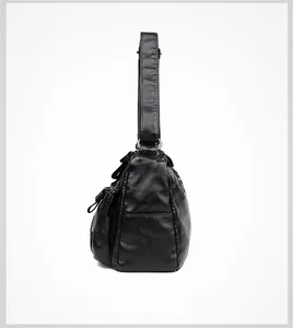Side view of black PU leather crossbody bag showing multiple pockets and metal hardware
