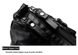 Detail of smooth silver metal double zippers on soft black lychee grain leather handbag