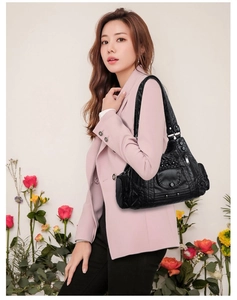 Detail of a black multi-pocket PU leather shoulder bag with vintage textured finish