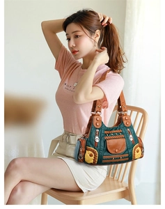 Detail of color-block patchwork tote bag with woven texture and gold ring charm decoration