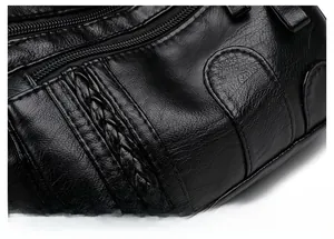 Detail of black soft PU leather texture with zipper and woven strap on crossbody bag