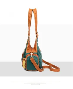 Detail of color-block PU leather handbag showing side zipper pocket and texture