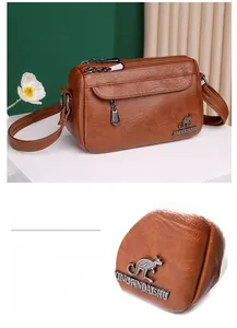Detailed view of brown lychee texture leather handbag with metal kangaroo logo
