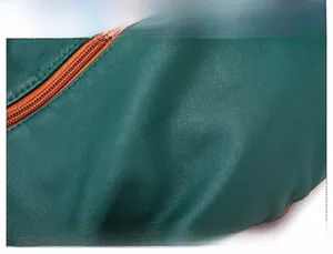 Close-up of green lychee pattern leather texture with orange-brown zipper stitching detail