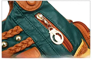 Macro shot of gold-plated metal zipper and woven leather detail on a green tote bag