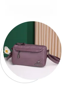 Detail of purple soft PU leather crossbody bag with kangaroo logo and dual metal zippers