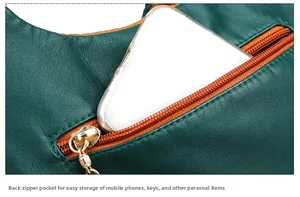 Close-up of green textured leather bag with orange lining and secure back zipper pocket