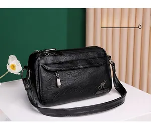 Close-up of black litchi pattern PU leather bag with metallic kangaroo logo detail