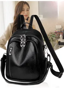 Close-up of black PU leather backpack featuring metal zippers and litchi grain texture