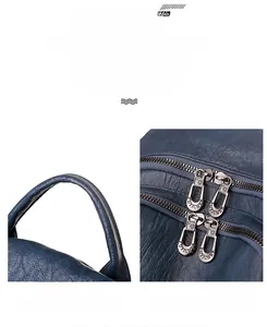 Detailed view of the dark blue faux leather backpack with reinforced handle and metal zippers