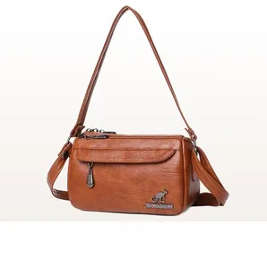 Detailed close-up of brown PU leather texture and silver kangaroo logo on crossbody bag