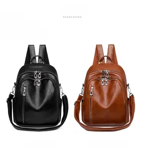 Detail view of stylish backpacks in black and caramel PU leather with zipper accents