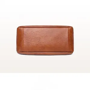 Detailed view of the brown PU leather bag bottom with reinforced double stitching