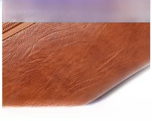 Close-up of premium brown PU leather texture and durable metal zipper on a shoulder bag