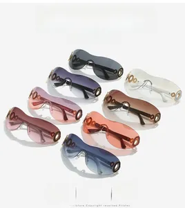 Close-up of Y2K oversized shield sunglasses featuring bold golden metal link hinges