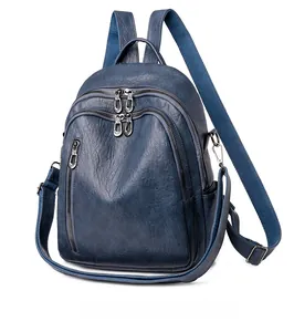 Side view of dark blue faux leather backpack with multiple zipper pockets and lychee texture