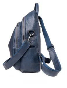 Side view of dark blue soft leather backpack with multi-layer zippers and silver hardware