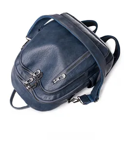 Macro detail of dark blue faux leather texture and zipper pockets on stylish backpack