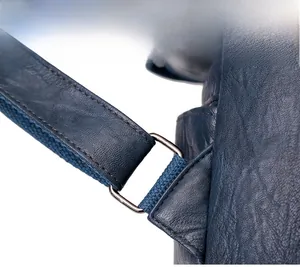 Detailed macro view of high-quality silver metal buckle on navy blue leather backpack