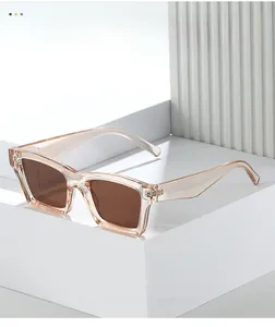 Detail view of square sunglasses with champagne resin frames and brown lenses on white blocks