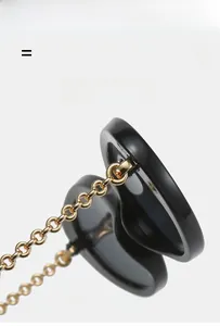 Close-up of stylish black sunglasses with golden chain and high-gloss hinge detail