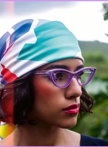 Close-up of stylish purple cat-eye glasses and colorful geometric silk scarf on a model
