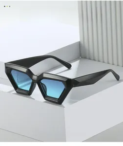 Detail of geometric rhombus sunglasses with black frames and blue gradient lenses