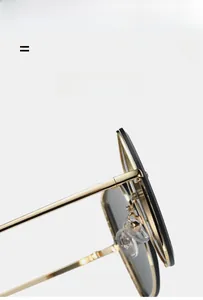 Detail of lightweight golden metal frame and black rim sunglasses with elastic hinges