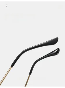 Macro detail of ergonomic gold metal temples with curved black tips on sunglasses
