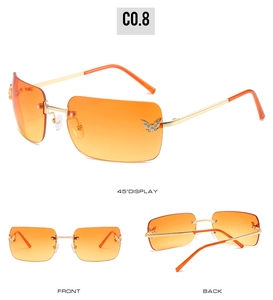 Detail view of rimless Y2K sunglasses with orange gradient lenses and rhinestone butterflies
