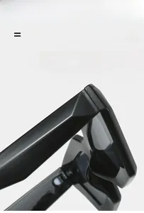 Detailed macro view of black geometric thick frame sunglasses with polished finish texture