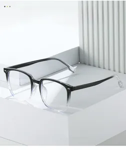 Detail view of large square black and clear gradient TR eyeglass frame on white stone