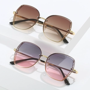 Fashionable oversized metal sunglasses with gradient lenses in brown and pink on a podium