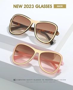Detail of oversized aviator glasses with metal frames and gradient lenses on white display