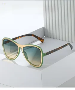 Detail of oversized retro aviator sunglasses with green frame and leopard print temples