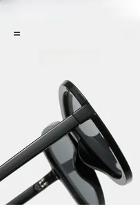Detail view of glossy black oversized sunglasses featuring flexible and lightweight texture