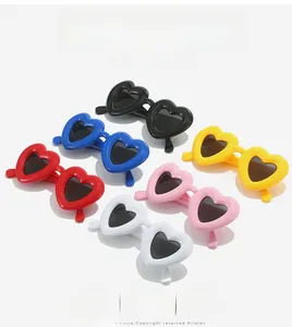 Flat lay of Y2K heart-shaped sunglasses in vibrant red, blue, pink, and yellow colors