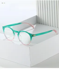 Detail of round gradient green to pink eyeglass frames with gold arrow accents