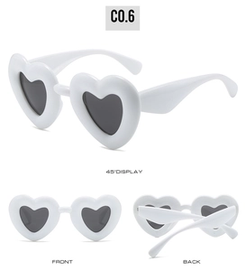 Macro view of white heart-shaped Y2K sunglasses with dark lenses from multiple angles