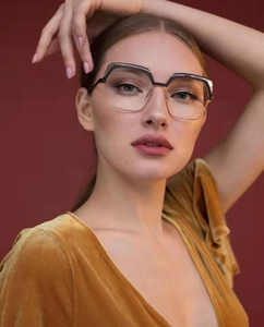 Macro detail of geometric black and gold metal glasses frames on a female model