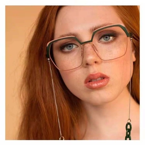 Detail of geometric two-tone glasses frame with metal chain on a female model
