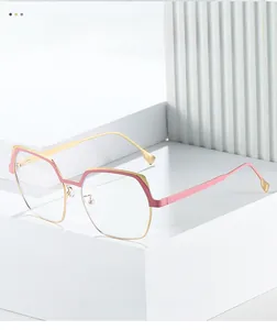 Detail of pink and gold geometric semi-rimless eyeglass frame on a white minimalist stand