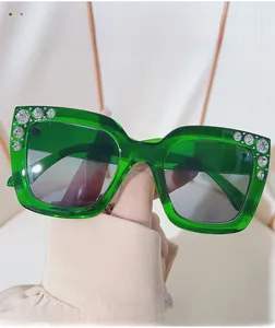Close-up of bright green square sunglasses with sparkling rhinestones and gradient lenses