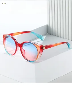 Détail de lunettes de soleil œil-de-chat dégradé rouge et bleu avec logo doré sur blocs