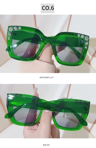 Detail view of green square sunglasses with sparkling rhinestone accents on the frame corners
