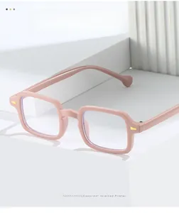 Gros plan de lunettes carrées roses à monture complète avec détails dorés sur blocs