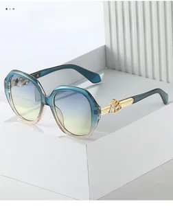 Close-up of golden metal temples with geometric engraving on gradient sunglasses