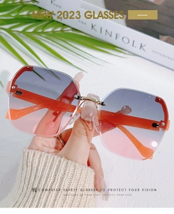 Close-up of frameless gradient sunglasses with gold metal bridge and rivet details